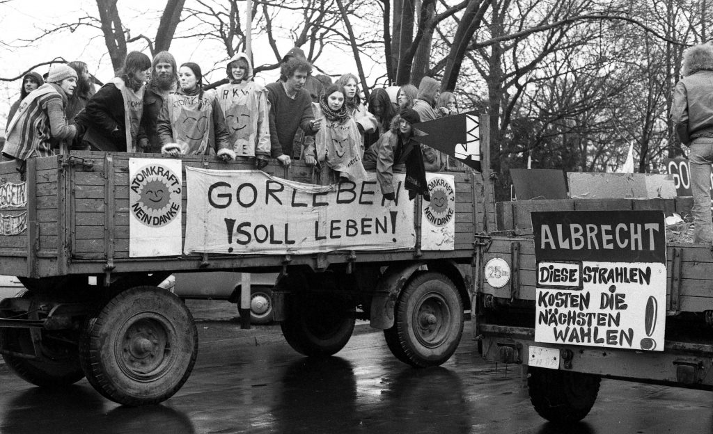 Gorlebentreck 1979 Der Abschluss des Gorleben-Trecks wird zur bis dahin größten Demonstration der Anti-AKW-Bewegung in der Bundesrepublik. Rund 100.000 Menschen empfangen den Treck der Bauern am 31. März 1979 in Hannover. Als Mahnmal und Erinnerung an den Treck bringen die Bauern einen großen Findling (»Gorleben-Stein«) mit, der bis heute am Weißekreuzplatz zu besichtigen ist. -- Die große Zahl der Teilnehmer ist auch auf einen Vorfall zurückzuführen, der sich wenige Tage zuvor in den USA ereignete. Im Atomkraftwerk Harrisburg (USA) kommt es am 28. März 1979 zu einem schweren Störfall, bei dem eine radioaktive Wolke aus der Anlage entweicht. Rund 200.000 Menschen müssen evakuiert werden. Ein noch schwererer Unfall konnte nur knapp vermieden werden. WAA, Anti AKW Bewegung, Treck der Bauern, Gorleben-Stein, Harriaburg, 19790331, 19790328, atomares Endlager, Gorleben-Treck, Gorleben