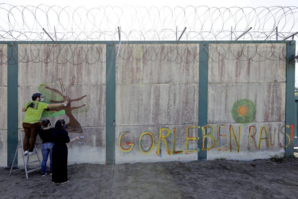 Graffiti-Aktion Gorleben Wendländische Atomkraftgegner/-innen sprühen ihre Botschaft an die Bundesgesellschaft für Endlagerung auf ein Reststück der Mauer, die das so genannte Erkundungsbergwerk in Gorleben jahrzehntelang hermetisch abgeriegelt hatte. Der Spruch "Gorleben raus"!" bezieht sich auf ihre Forderung, den Salzstock im Wendland mit der Vorstellung des "Zwischenberichts Teilgebiete" im Herbst 2020 aus dem Verfahren der Endlagersuche zu nehmen. Beim Abriss der Mauer 2019 ist ein Stück als Mahnmal stehen geblieben. Rechtliche Querelen verhindern aber noch den freien Zugang, so dass die Atomkraftgegner/-innen Leitern zum Überwinden des Zauns mitbrachten.
Ort: Gorleben
Copyright: Andreas Conradt
Quelle: PubliXviewinG